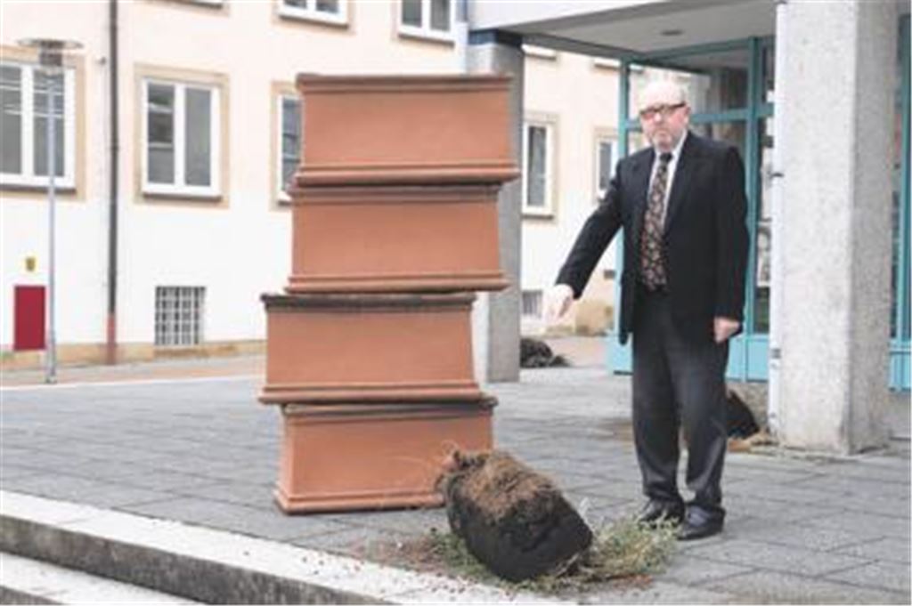Kopfschütteln über die nächtlichen Späße: Roland Knapp und gestapelte Pflanztröge. 
Foto: Franz