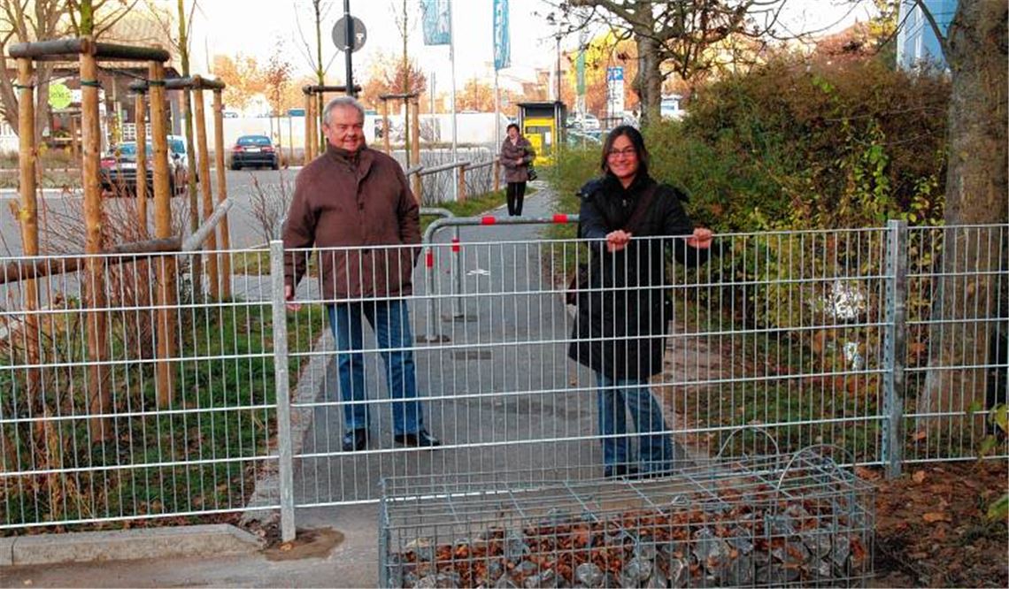 Kopfschütteln und Galgenhumor: Der neue Fußweg hinter dem Modehaus Sämann, zwischen Goethestraße und Stadtmitte, endet für die Passanten in einer Sackgasse – eine Nachbarin hat den Durchgang in Richtung Fußgängerzone und Kelterplatz mit einem Metallzaun blockiert. Den Fußgängern bleibt, um das Hindernis zu umgehen, nur ein Umweg über die Parkplätze bis hin zur B10 und zurück.