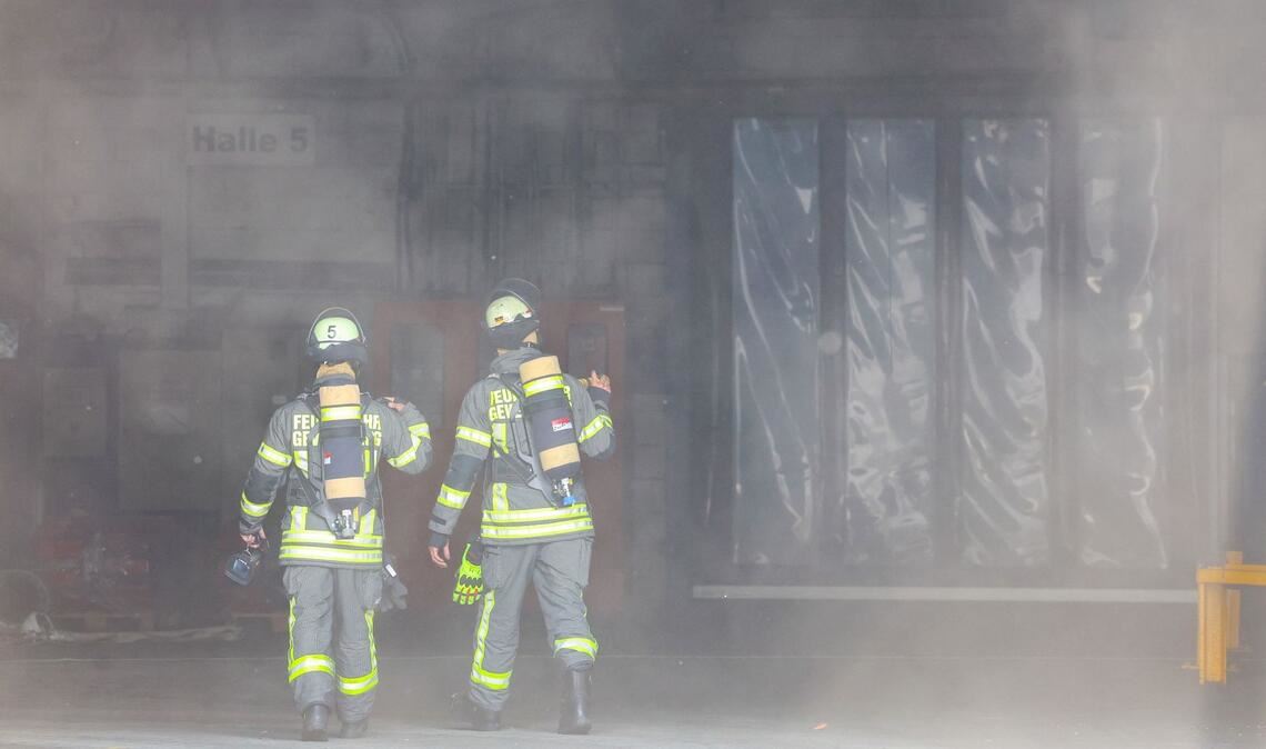 Kräfte der Feuerwehr verschaffen sich nach der Explosion in einer Industriehalle einen Überblick.