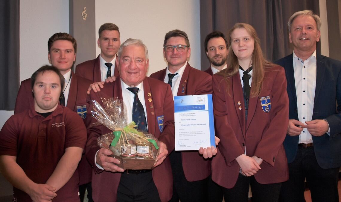 Kreisverbandsvorsitzender Heiko Genther (re.) ehrt verdienstvolle aktive Musiker des Musikvereins Mühlacker. Mit 70-jährigem Spiel am Flügelhorn übertrumpft der 83-jährige Hans Vollmer (Mitte) alle seine Kolleginnen und Kollegen. Foto: Filitz
