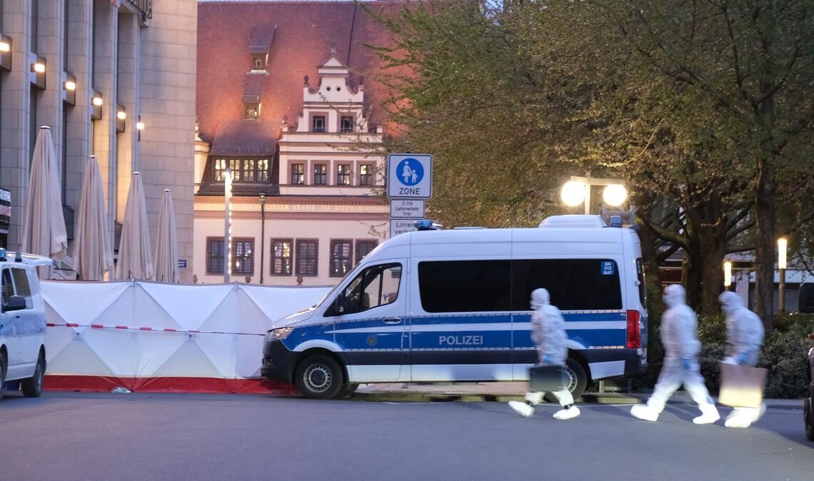 Kriminaltechniker gehen zum Tatfahrzeug.