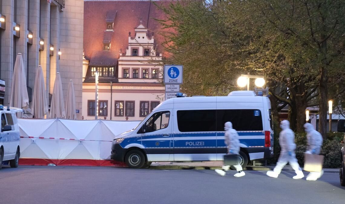 Kriminaltechniker gehen zum Tatfahrzeug. In Leipzig ist ein Auto in mehrere Menschen gefahren.