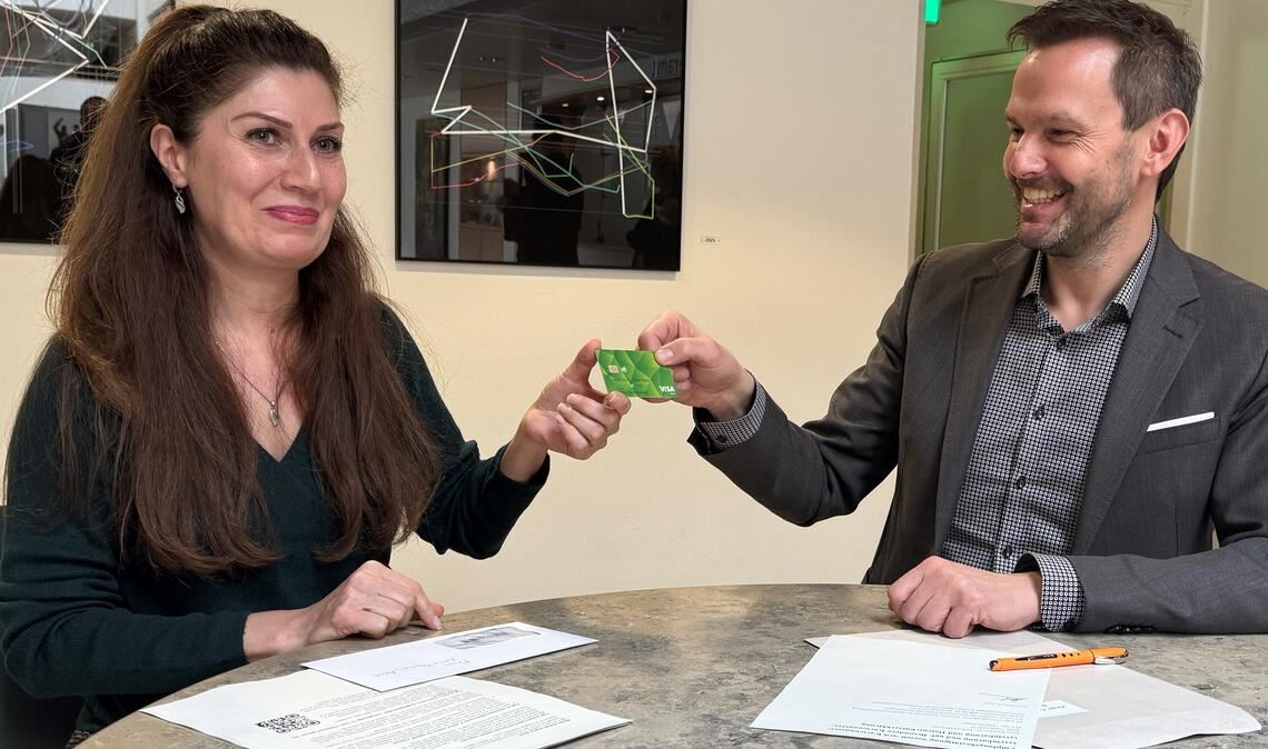 Landrat Bastian Rosenau übergibt die erste Bezahlkarte. Mit ihr können Asylbewerber bargeldlos einkaufen, in der Regel aber nur 50 Euro im Monat abheben. Foto: Goertz