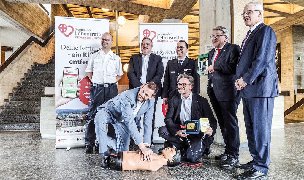 Landrat Bastian Rosenau und Oberbürgermeister Peter Boch (kniend, v.li.) zeigen bei der Einführung der „Region der Lebensretter“-App vollen Einsatz beim Reanimationstraining. Über den Startschuss des Projekts freuen sich außerdem Kreisbrandmeister Carsten Sorg (v.li.), DRK-Kreisgeschäftsführer Herbert Mann, Sebastian Fischer (Pforzheimer Feuerwehrkommandant), DRK-Kreisverbandspräsident Dr. Wolfgang Kramer sowie Dr. Georg Trummer, Mitgründer des Vereins „Region der Lebensretter“ aus Freiburg. Fotos: Deeg