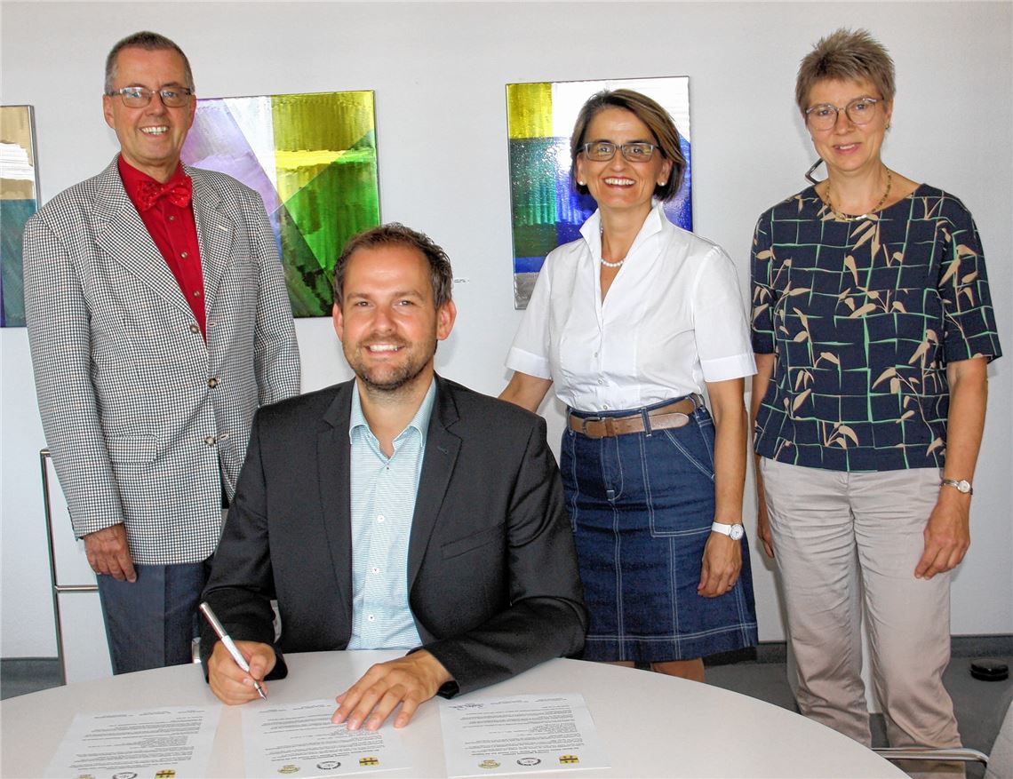 Landrat Bastian Rosenau unterzeichnet strahlend die Partnerschaftsurkunde mit Masasi. Mit ihm freuen sich (v. li.) der Erste Landesbeamte und Klimaschutzdezernent Wolfgang Herz, Stabsstellen-Leiterin Edith Marqués Berger und die Vorsitzende des Partnerschaftsvereins, Angela Gewiese.