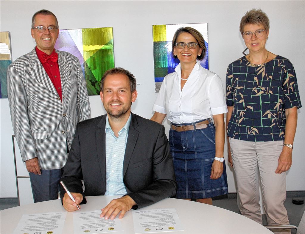Landrat Bastian Rosenau unterzeichnet strahlend die Partnerschaftsurkunde mit Masasi. Mit ihm freuen sich (v. li.) der Erste Landesbeamte und Klimaschutzdezernent Wolfgang Herz, Stabsstellen-Leiterin Edith Marqués Berger und die Vorsitzende des Partnerschaftsvereins, Angela Gewiese.