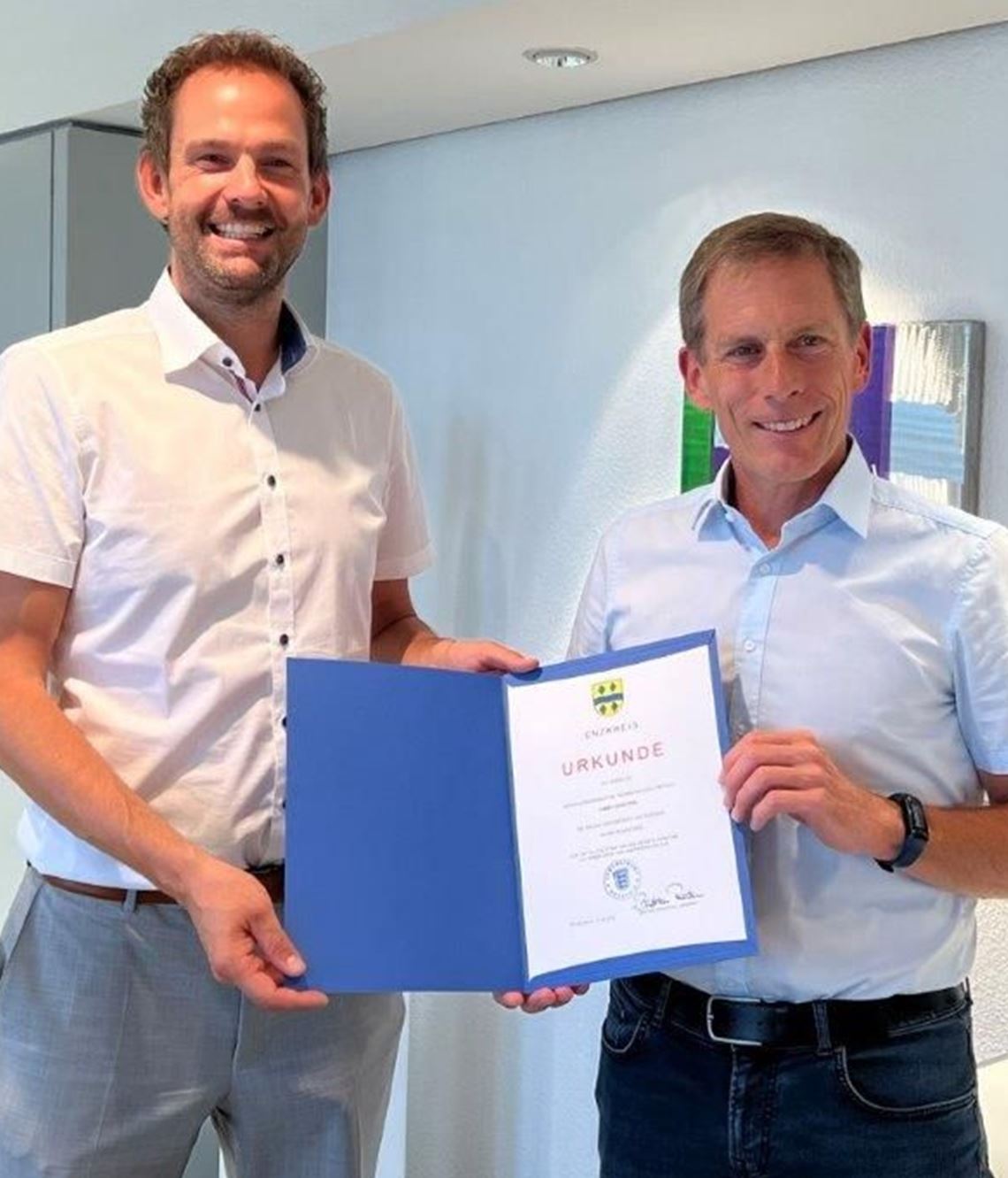 Landrat Rosenau (li.) überreicht Thomas Fritsch die Entlassungsurkunde. Foto: Saraie