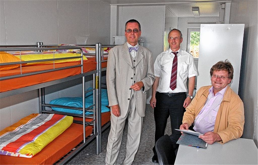 Landrat-Vize Wolfgang Herz, Andreas Kraus, Leiter des Enzkreis-Ordnungsamts, und Bürgermeister Karlheinz Oehler (v. li.) in den neuen Containern für Asylbewerber. Foto: Goertz