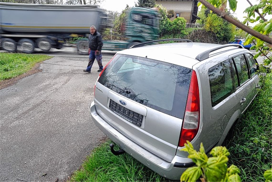 Schrottauto in Landschaft entsorgt
