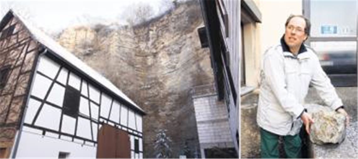 Leben an der Steilwand: Handwerksmeister und Stadtrat Matthias Trück mit einem Brocken, der vor der Sicherung der Felswand herabgefallen ist und das Dach der Werkstatt beschädigt hat.
Fotos: Franz