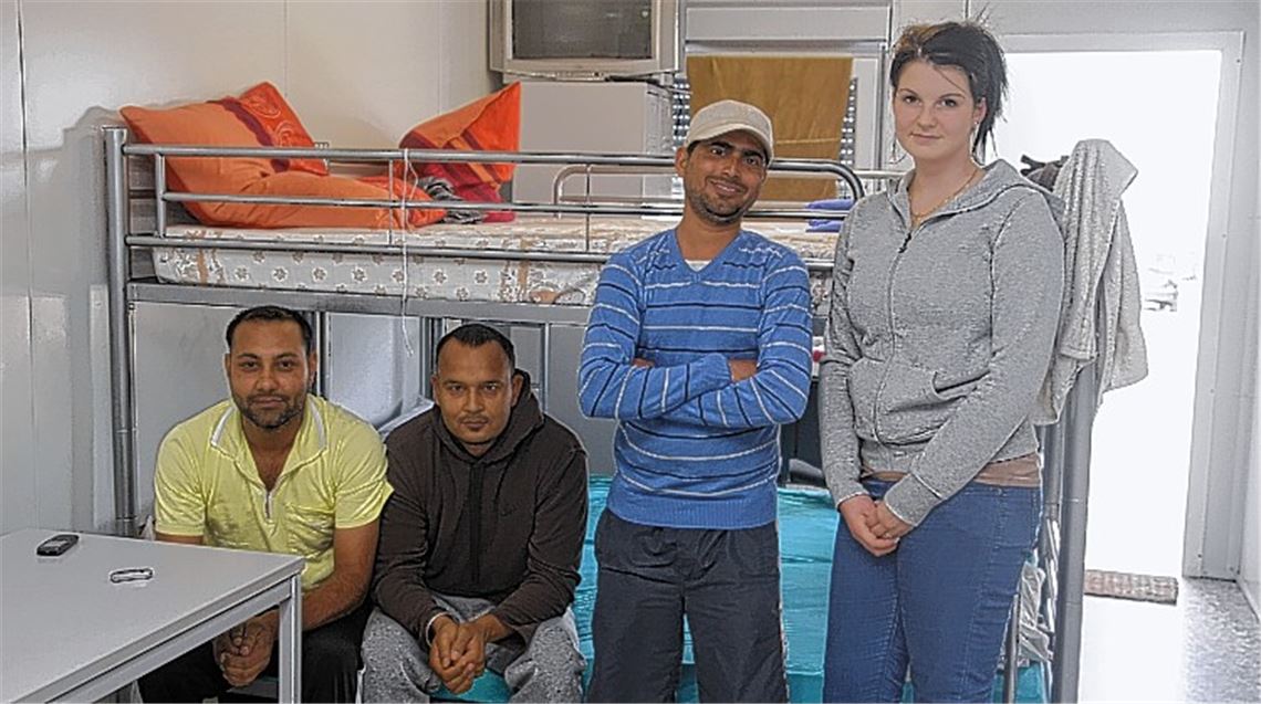 Leben auf engstem Raum, aber in Sicherheit: Drei Familien und Alleinstehende aus dem Iran, Serbien, Afghanistan, Indien und Gambia sind in den Wohncontainern für Asylbewerber in Wiernsheim untergebracht – im Bild drei Flüchtlinge aus Indien zusammen mit Tanja Lazic von der Gemeindeverwaltung. 