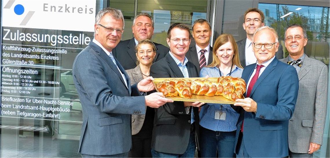 Leckerer Schlüssel zur neuen Zulassungsstelle (v. li.): Wilfried Wibusch und Lothar Girrbach (beide Geschäftsführer Bau und Grund), Miriam Mayer und Oliver Müller (vom Landratsamt), Lothar Hein (Technischer Leiter Bau und Grund), Katharina Horak (stellvertretende Leiterin Zulassungsstelle), Architekt Jochen Freivogel, Landrat Karl Röckinger und sein Vize Wolfgang Herz. Foto: Roth