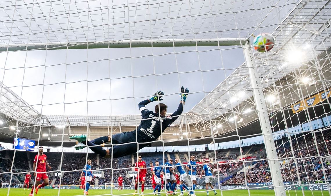 Leipzigs Christopher Nkunku (verdeckt) macht das Tor zum 0:1 gegen Hoffenheims Torwart Oliver Baumann (l).