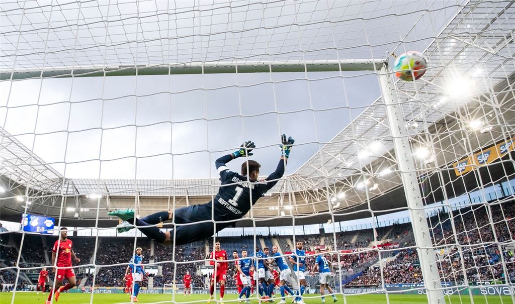 Leipzigs Christopher Nkunku (verdeckt) macht das Tor zum 0:1 gegen Hoffenheims Torwart Oliver Baumann (l).