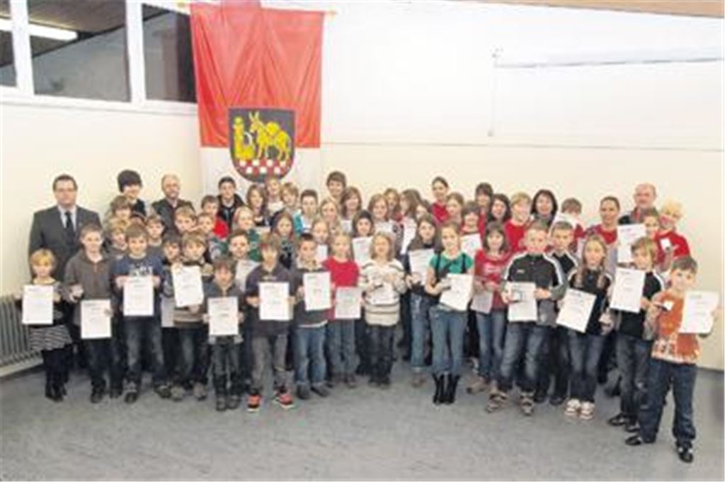 Leistungsträger aus Maulbronn, Zaisersweiher und Schmie versammeln sich mit Urkunden zum Gruppenfoto: Bei der Sportlerehrung der Stadt Maulbronn kann Bürgermeister Andreas Felchle (li.) vorwiegend jüngere Athleten auszeichnen, die im Laufen, Springen, Werfen und Co. in diesem Jahr herausragende Platzierungen erreicht haben.
 Foto: Fotomoment