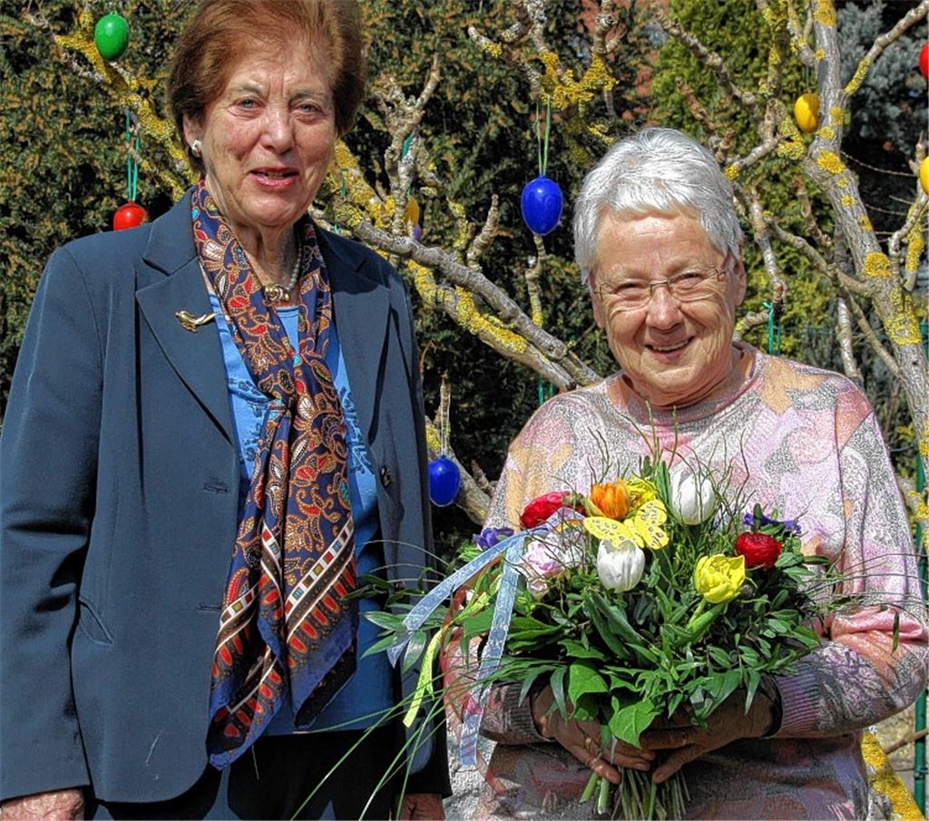 Leserin Anneliese Becker (re.) freut sich über die einen Strauß Blumen, übergeben durch Verlegerin Brigitte Wetzel.