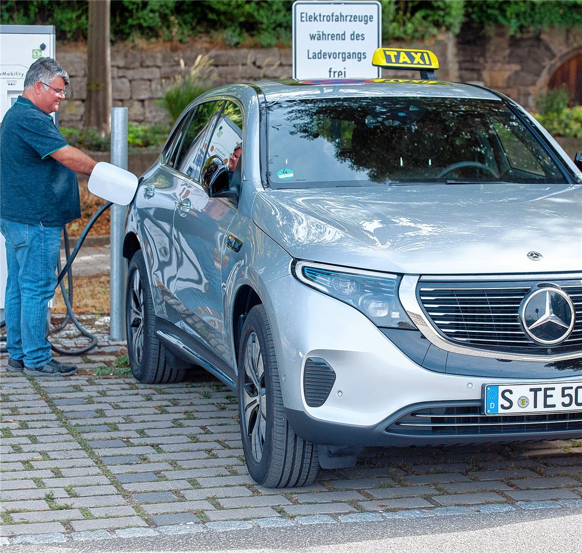 Levent Özer vom Taxi-Unternehmen 2400 GmbH beim Laden des E-Mercedes. Foto: Fotomoment