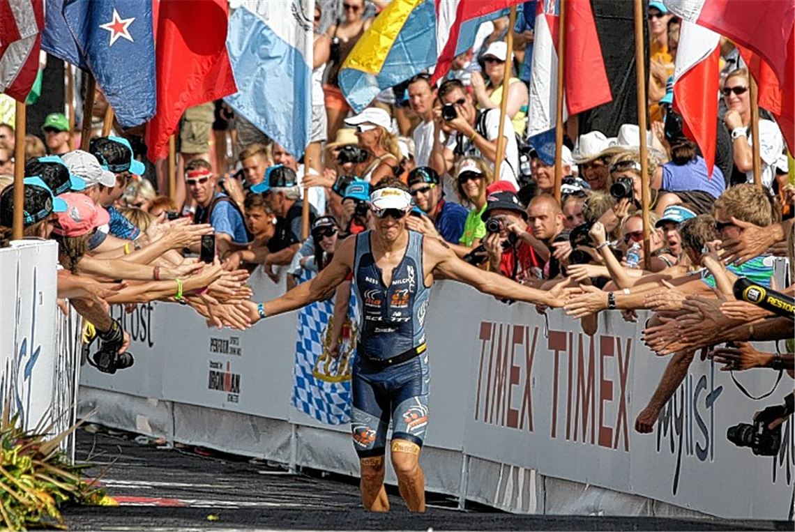 „Lieber mit so einem Rennen Vierter als mit einem perfekten Rennen Dritter“: Sebastian Kienle feiert mit der Menge, als er nach 8:27:08 Stunden ins Ziel kommt. Foto: dapd