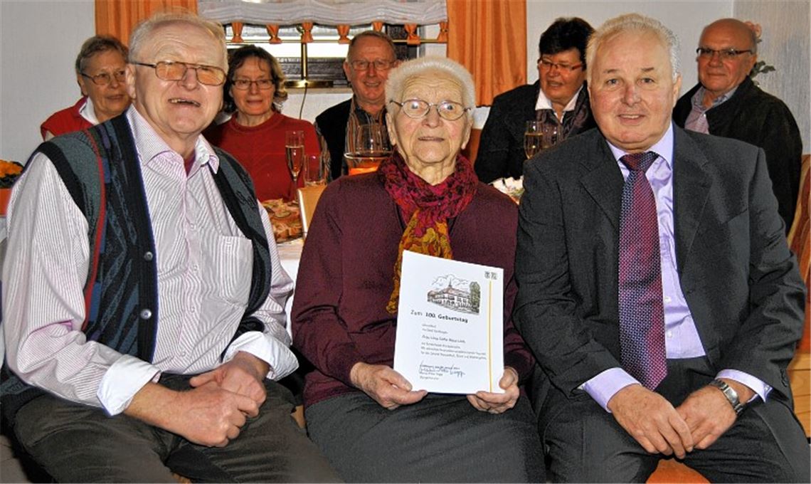 Lina Link, geborene Plag, feierte am Mittwoch ihren 100. Geburtstag. Bürgermeister-Stellvertreter Walter Fink (re.) gratulierte für die Fauststadt. Links: Sohn Gerhard. Foto: Haller