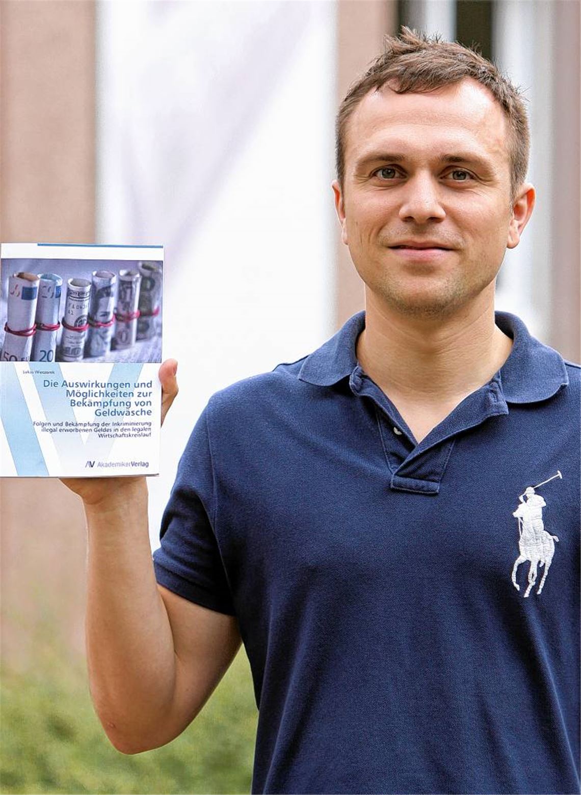 Lukas Wieczorek mit seinem Buch zum Thema Geldwäsche, ihren Auswirkungen und den Möglichkeiten zur Bekämpfung. Foto: Goertz
