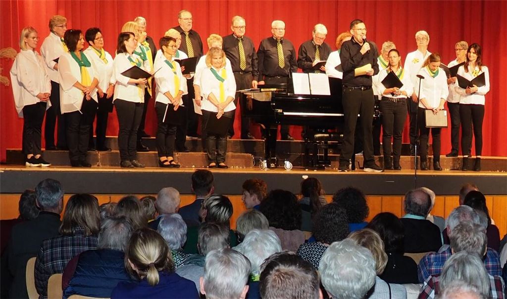 MGV-Vorsitzender Stefan Mast (mit Mikrofon) begrüßt zusammen mit dem jungen Chor „Klangtastisch“ die rund 300 Gäste im Saal der Erlentalhalle.Foto: Müller