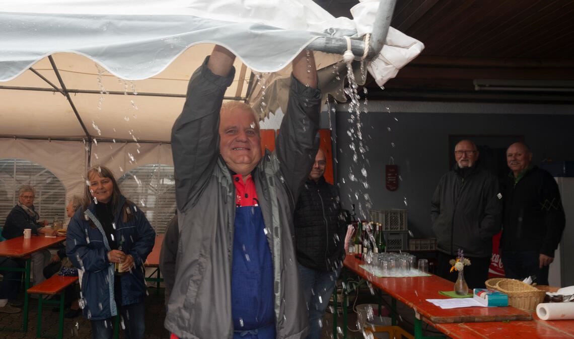 Festzelt fliegt um ein Haar davon Manfred Pfeil befreit einmal mehr das Zeltdach vom Regenwasser. Foto: Fotomoment
