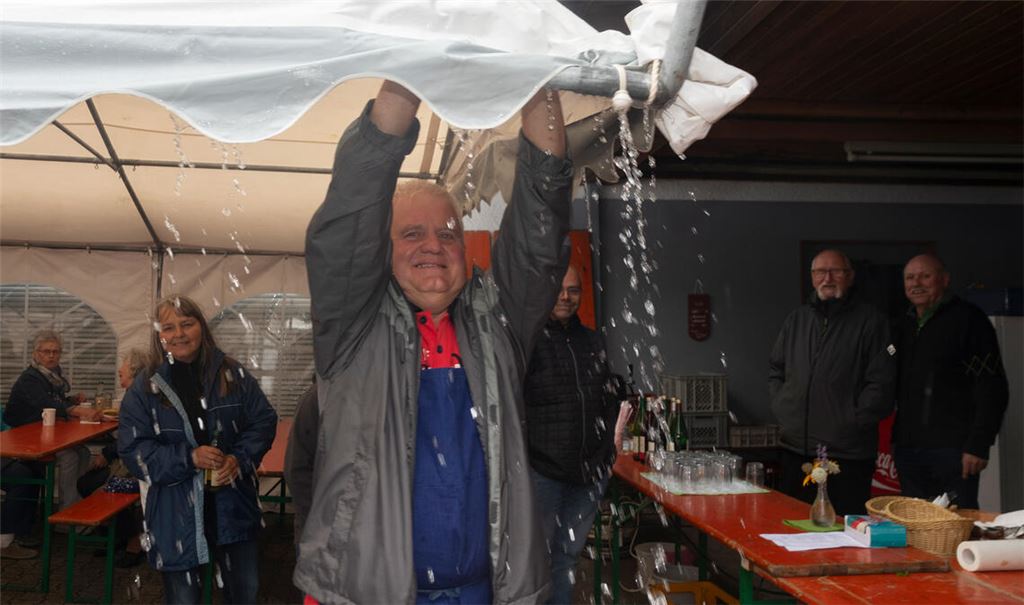 Manfred Pfeil befreit einmal mehr das Zeltdach vom Regenwasser. Foto: Fotomoment