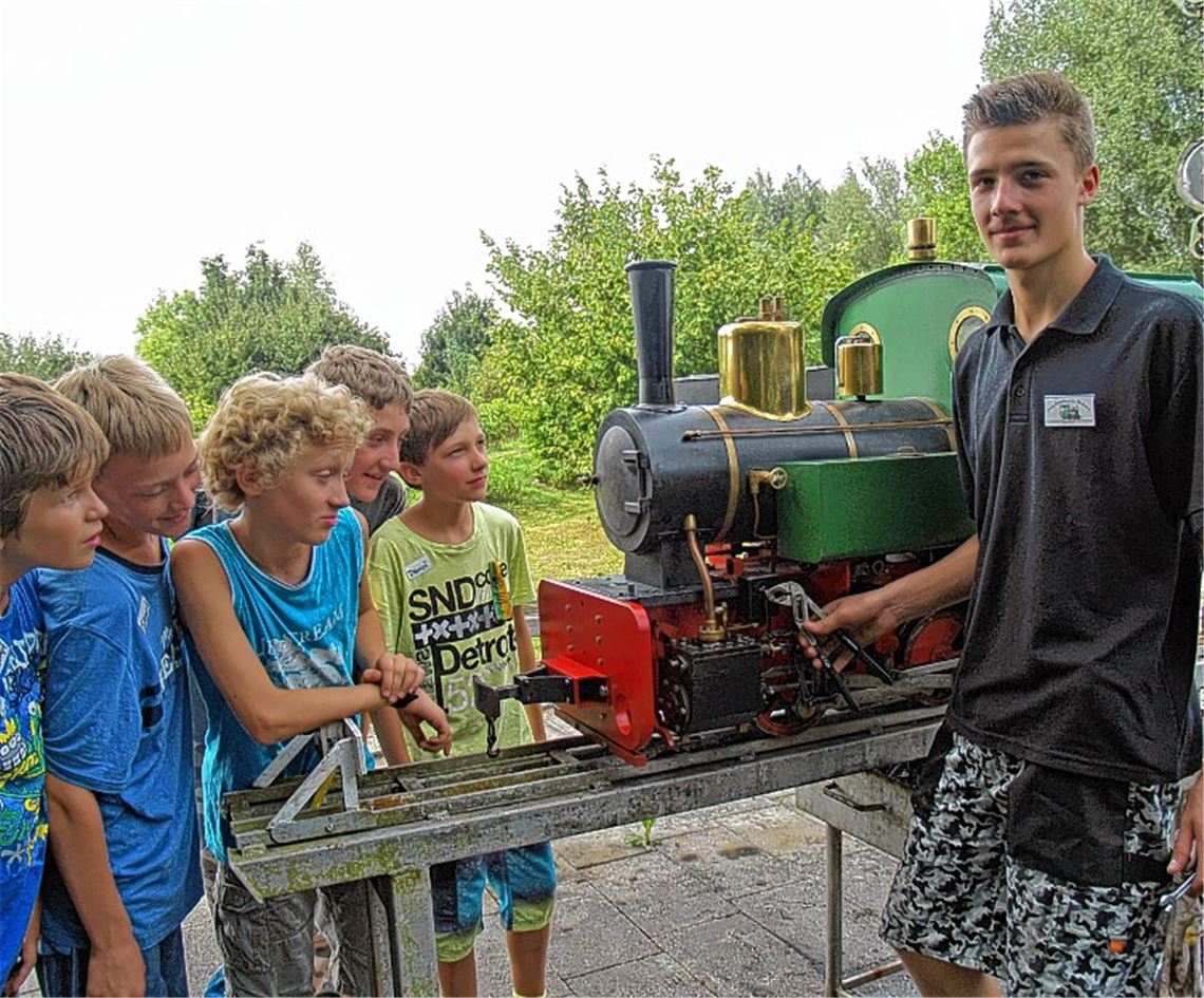 Manuel, 15 Jahre alt und seit vier Jahren „Eisenbahner“, erklärt den jungen Gästen die Technik der Dampflokomotive – und warum sie repariert werden muss.