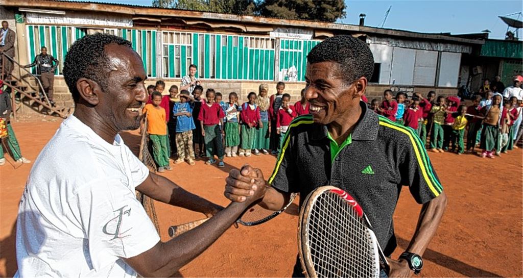 Marathonläufer und Superstar Haile Gebrselassie (re.) besucht die Tenniskinder und Tariku Tesfaye, einen ihrer Trainer, der von Anfang an beim außergewöhnlichen Tennisprojekt dabei ist.