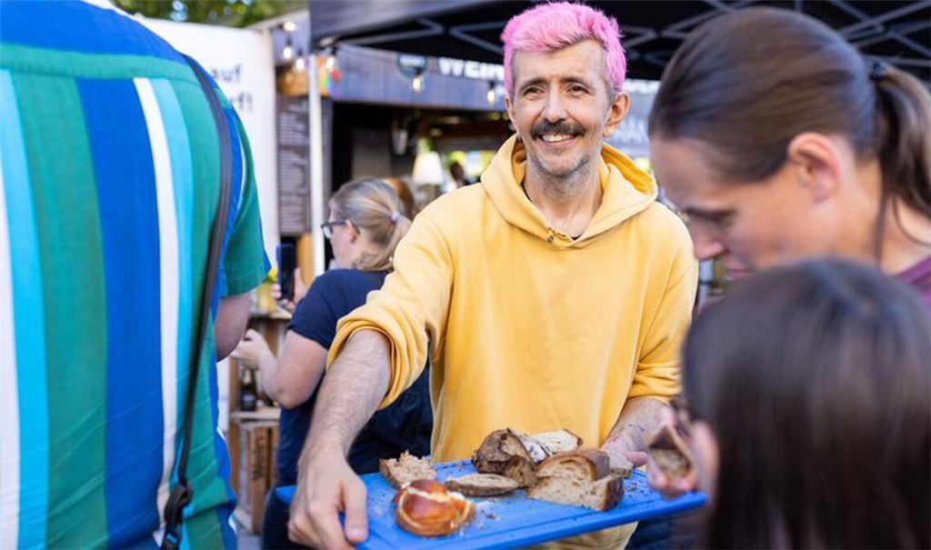 Marko Špehar-Piehler verteilt selbstgebackenes Brot auf dem Weindorf in Stuttgart.