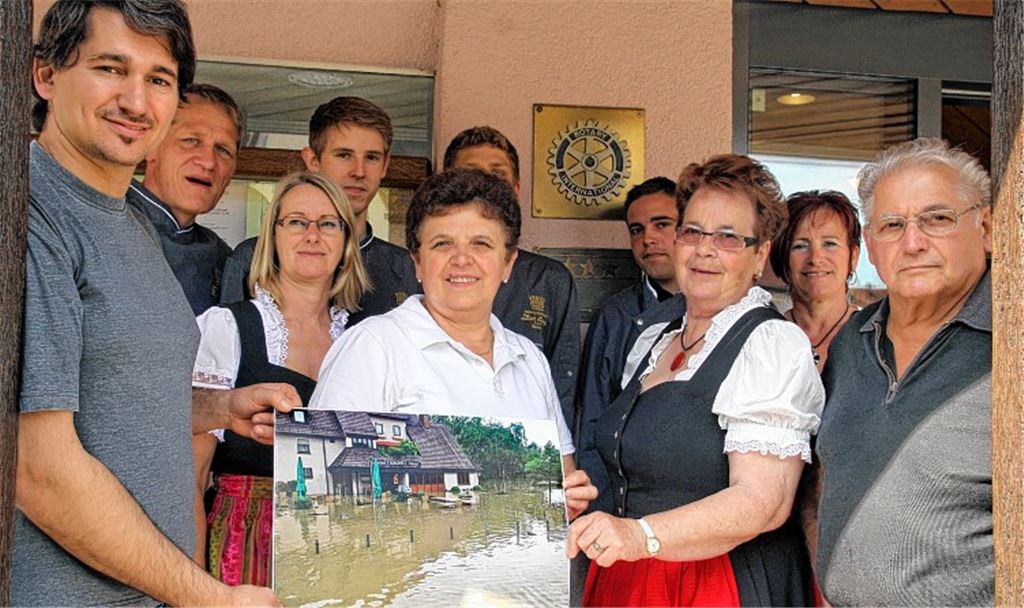 Markus Münchinger (li.) und sein Team haben es geschafft: Nur ein Foto erinnert noch daran, wie hoch das Wasser vor und in dem Hotel-Restaurant „Krone“ in Ötisheim am Samstag gestanden hat. Foto: Goertz