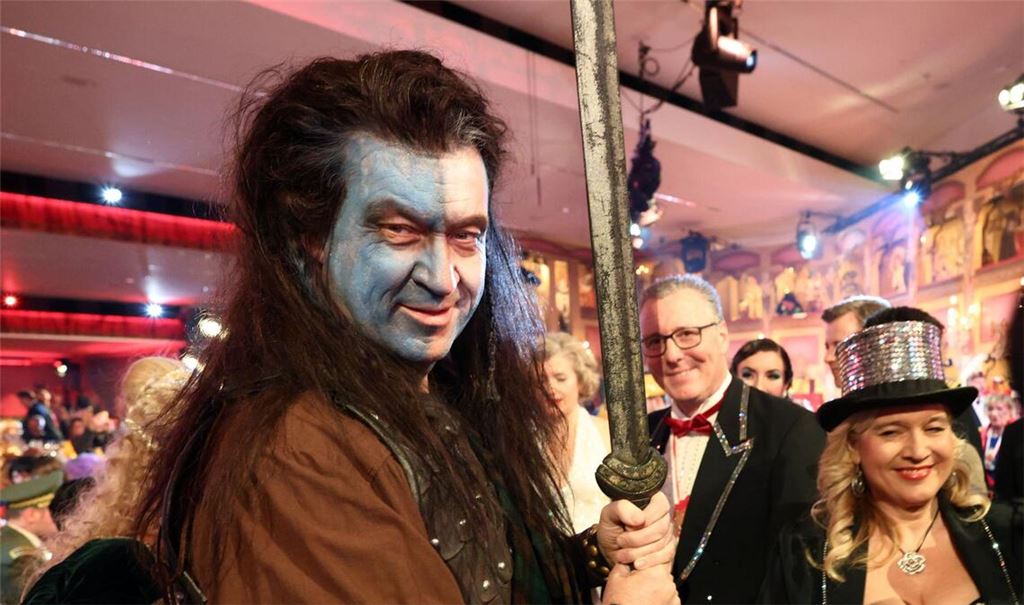 Markus Söder (l, CSU), Ministerpräsident von Bayern, nimmt als „Braveheart“ an der BR-Livesendung „Fastnacht in Franken“ in den Mainfrankensälen teil.