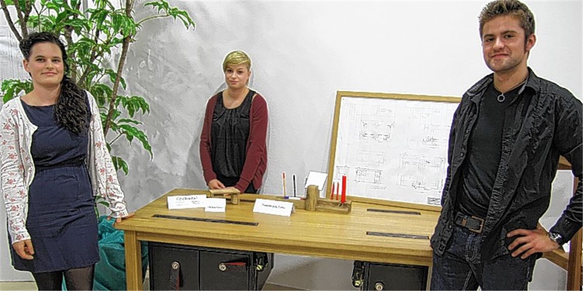 Marlen Katz (v.li.) und Merle Koch schauen sich das Gesellenstück von Paul Grüneich an.