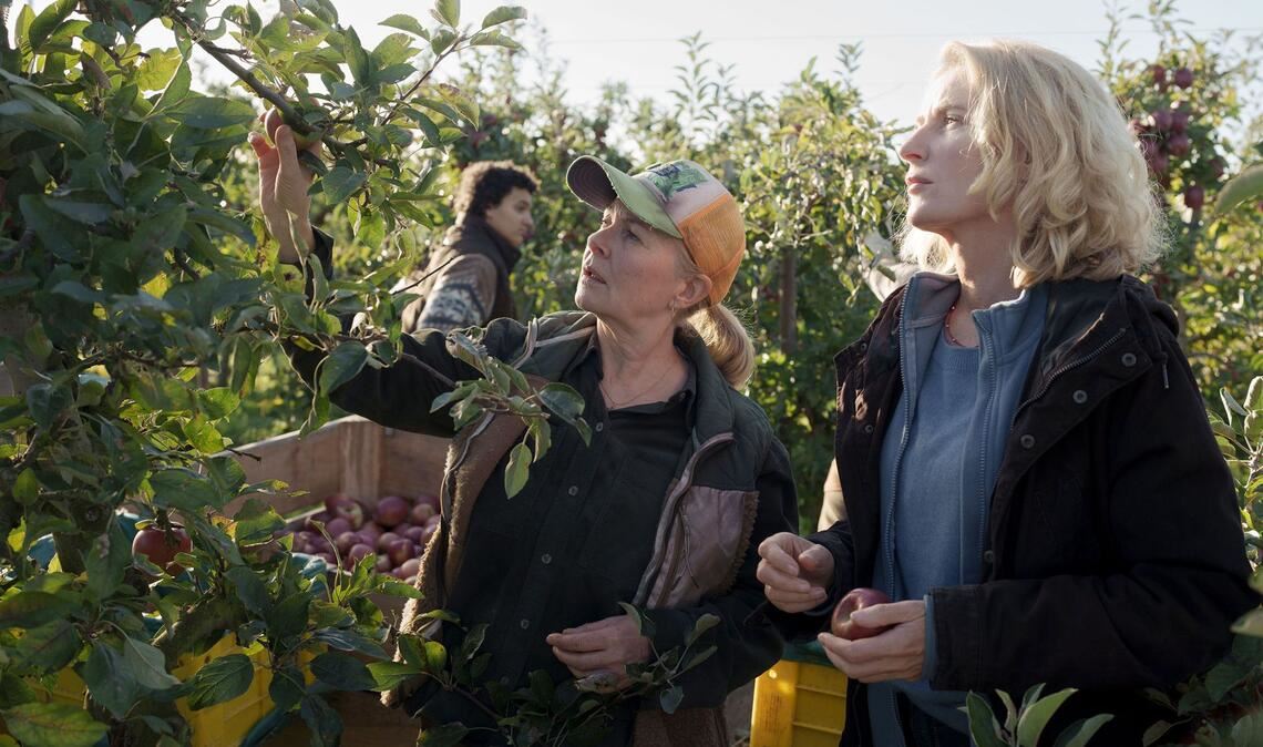 Marlies Feldhusen (Lina Wendel, M.) weist Charlotte (Maria Furtwängler, r.) in die Apfelernte ein.