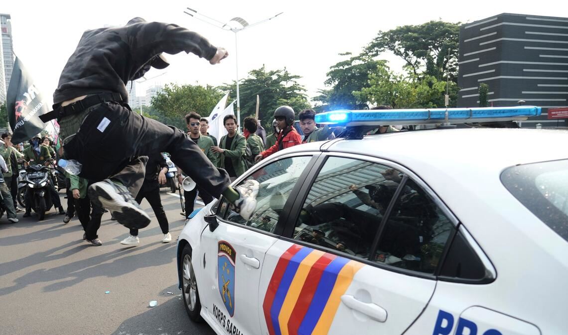Bilder des Tages Massenproteste gegen die Regierung in Indonesien: ein Demonstrant attackiert ein Polizeiauto.