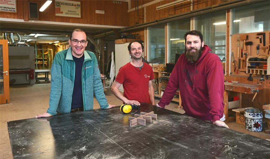 Matthias Fleig (li.) begrüßt Tobias Dobler (Mitte) und Samuel Kraus vom Team der „Holzwerkstatt Störrmühle“ im Bankraum der Heinzelmann-Schreinerei. Fotos: Schüller