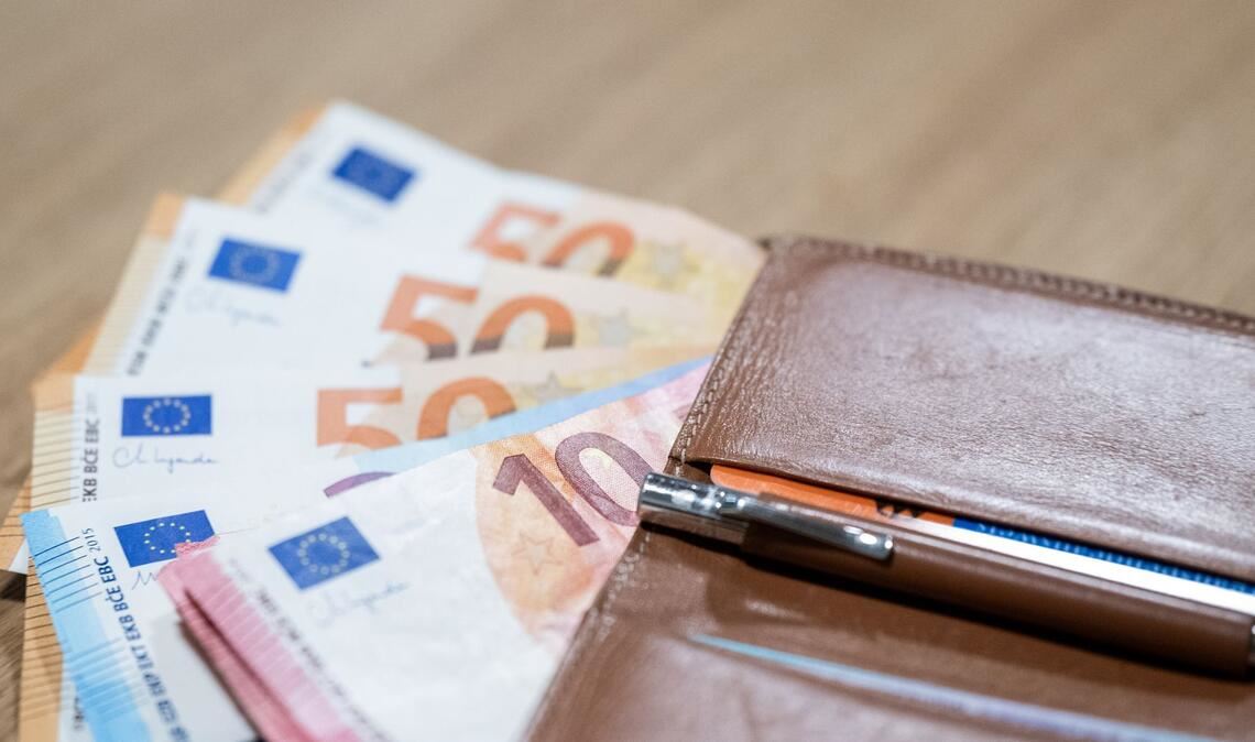 Mehrere Euro-Scheine liegen mit einer Geldbörse auf einem Tisch. (Symbolfoto)
