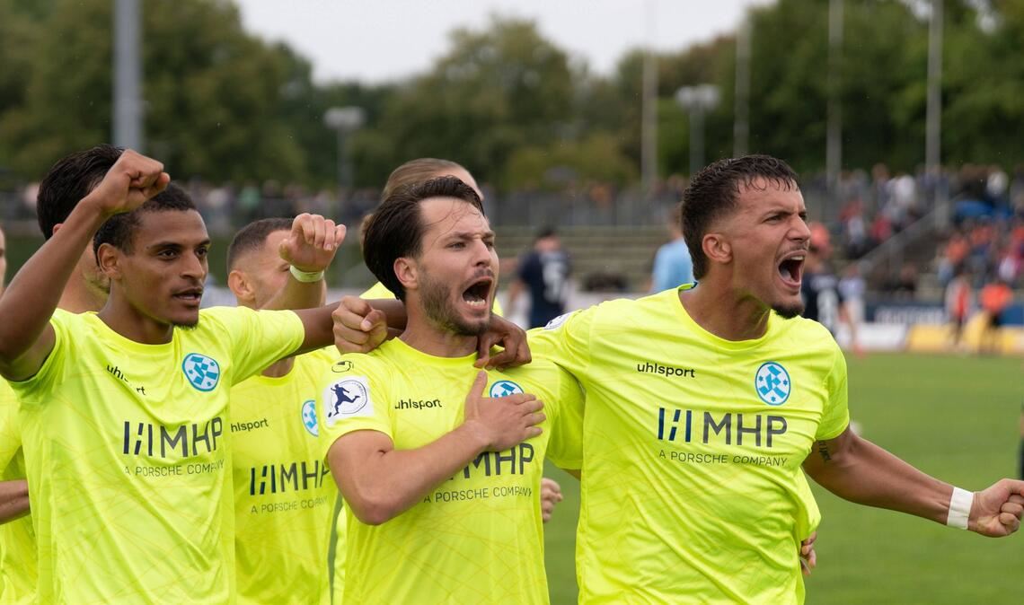 Reife Leistung – starker Saisonstart der Kickers Melkamu Frauendorf, Torschütze David Tomic und Milan Petrovic (v.li.) jubeln vor den mitgereisten Kickers-Fans über den Auswärtssieg.
