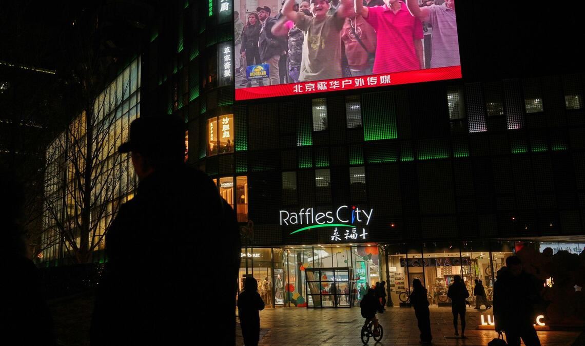 Menschen beobachten in China eine Übertragung einer Kundgebung aus Caracas.