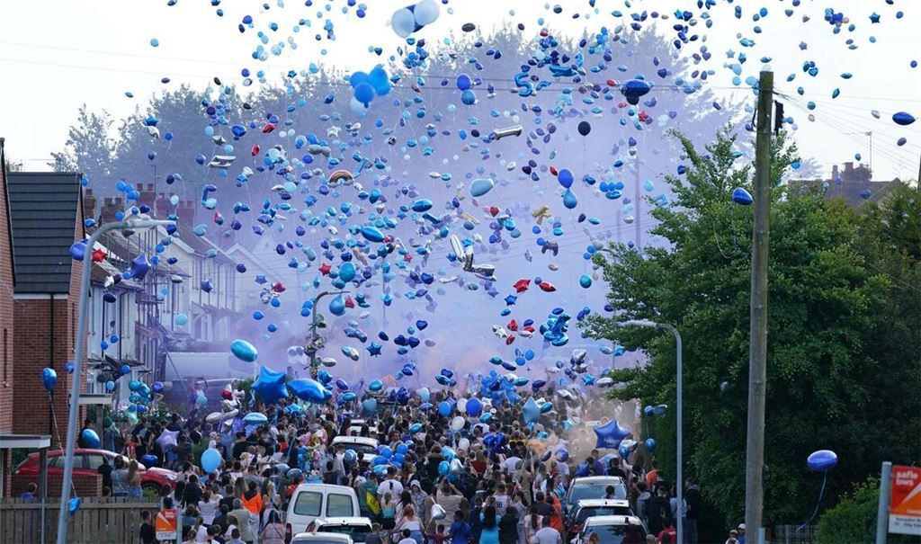 Menschen lassen während einer Demonstration für die Opfer eines Verkehrsunfalls im britischen Ely Luftballons steigen. Damit wollen sie an einen 15- und einen 16-Jährigen erinnern, die bei einem Verkehrsunfall getötet wurden.