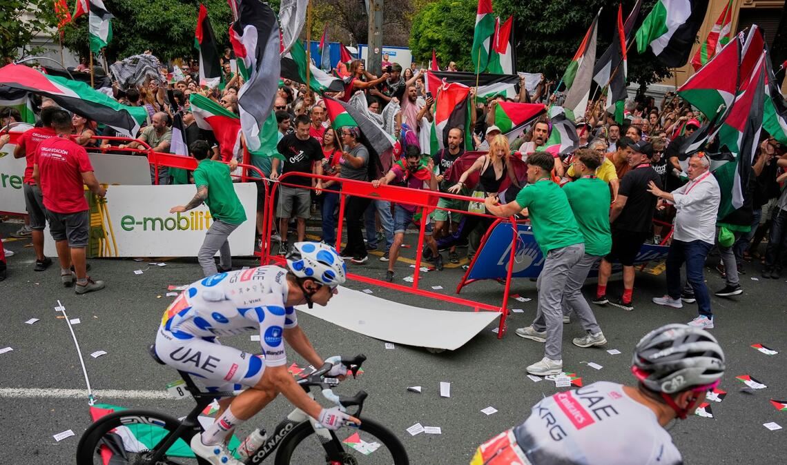 Menschen protestieren an der Strecke mit palästinensischen Fahnen gegen die Teilnahme des Radrennstalls Israel-Premier Tech an der Vuelta á España