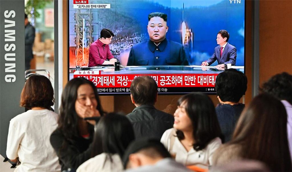 Menschen schauen im  Bahnhof in Seoul auf einen Bildschirm, auf dem eine Nachrichtensendung mit Filmmaterial von Nordkoreas Führer Kim Jong Un zu sehen ist.