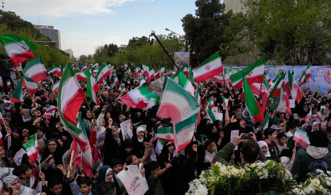 Menschen schwenken iranische Fahnen bei einer Gedenkfeier für Schulkinder, die am 28. Februar bei einem US-Luftangriff auf eine Schule in  Minab getötet wurden.