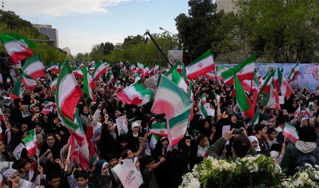 Menschen schwenken iranische Fahnen bei einer Gedenkfeier für Schulkinder, die am 28. Februar bei einem US-Luftangriff auf eine Schule in  Minab getötet wurden.
