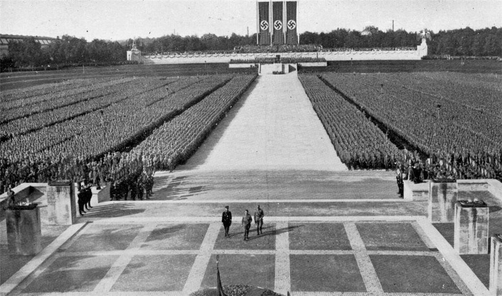 Menschenblöcke als Kulisse: Adolf Hitler, Reichsführer-SS   Himmler  und  SA-Führer  Lutze schreiten beim Reichsparteitag 1934 zur  Totenehrung in der Luitpoldarena.

Foto: imago