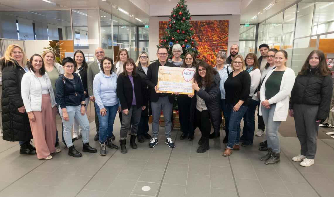 Michael Fritz (Mitte) übergibt die Spenden an die Erzieherinnen der 40 Kindergärten. Foto: Fotomoment