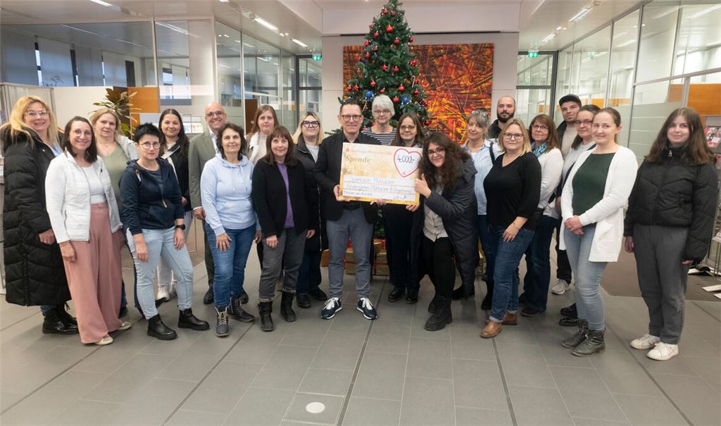 Michael Fritz (Mitte) übergibt die Spenden an die Erzieherinnen der 40 Kindergärten. Foto: Fotomoment