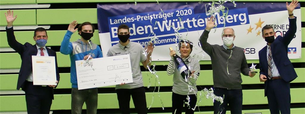 Michael Kopf (Bereichsleiter Volksbank Pforzheim, li) und Ralf Günther-Schmidt (Vorstandsmitglied Volksbank Pforzheim, re.) übergeben den Preis an Beate Lupus (SG-Jugendleiterin) und an den Vorstandsvorsitzenden Jörg Lupus (2. v. re.). Mit dabei sind auch Spieler der SG.Foto: privat