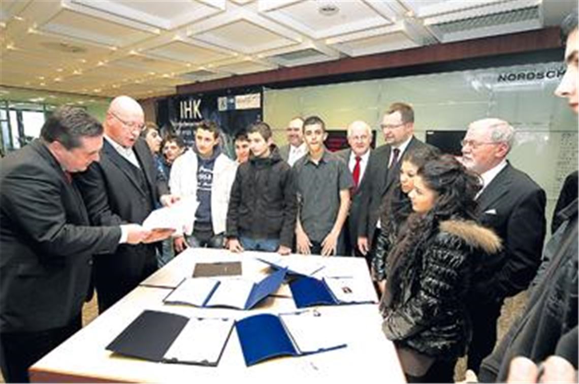 Ministerpräsident Stefan Mappus (li.) und Porsche-Betriebsratschef Hück spicken in die Bewerbungsmappen, die Schüler zum Ausbildungsgipfel mitbringen. Foto: Kollros