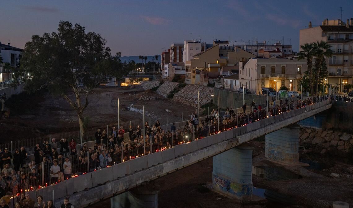 Mit Kerzen in Händen bilden Teilnehmer einer Gedenkveranstaltung eine Menschenkette in Paiporta in der Region Valencia, um an die Opfer der Flutkatastrophe vom Oktober 2024 zu erinnern.